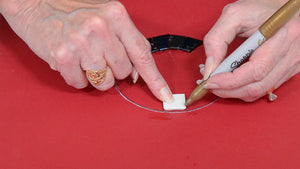 woman demonstrating how to cut mosaic tiles to fit in a circle